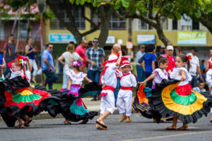 Niños y niñas bailan con trajes típicos en celebración del Día de la Independencia de Costa Rica